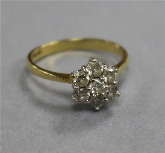 A modern 18ct gold and seven stone diamond cluster ring, size O.